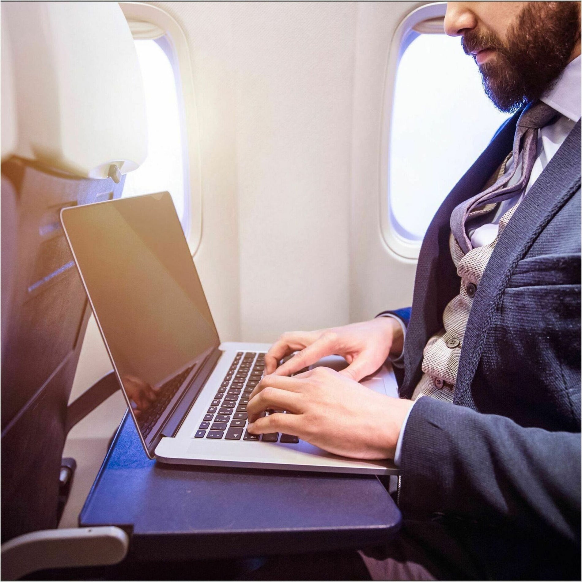 Business professional using laptop with privacy screen while working on airplane-alternate-image6