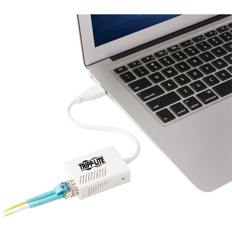 Tripp Lite fiber adapter connected to laptop USB port with fiber cable attached