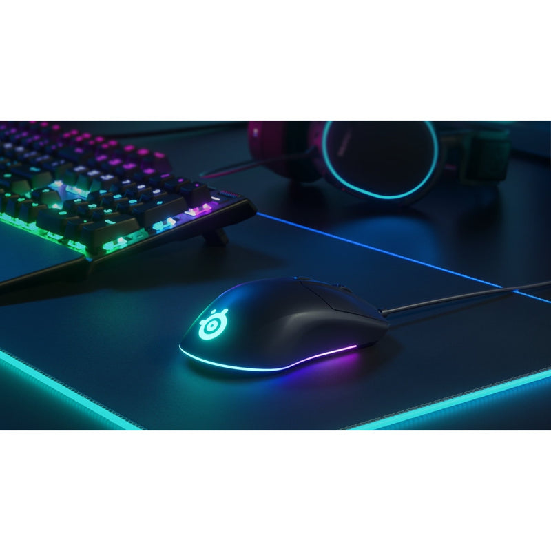 SteelSeries Rival 3 in a gaming setup with RGB keyboard