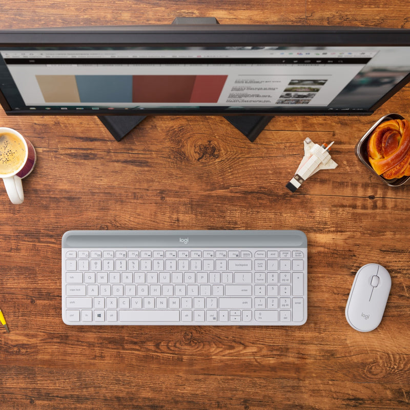 Logitech MK470 keyboard and mouse on wooden desk with monitor and office accessories