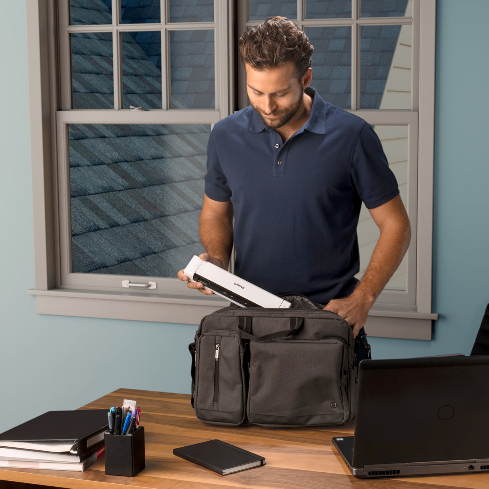 Professional storing Brother DS740D scanner in laptop bag demonstrating portability-alternate-image4