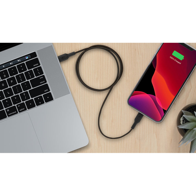 Lifestyle image showing Belkin cable connected between MacBook and iPhone on wooden desk