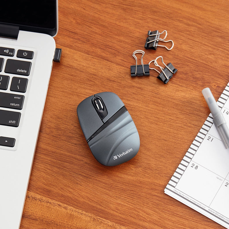 Lifestyle image showing Verbatim Wireless Mini Travel Mouse in use with laptop and office supplies