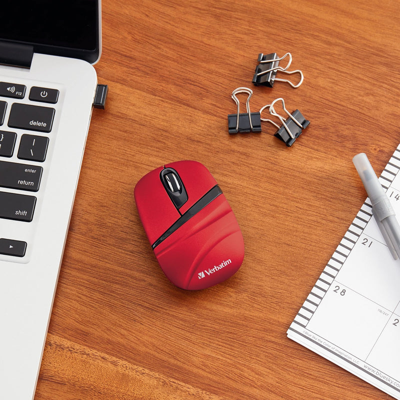 Red Verbatim wireless mouse on wooden desk with laptop and office supplies