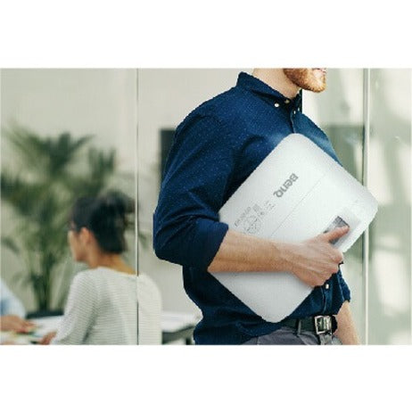 Person carrying BenQ MW560 projector in office environment