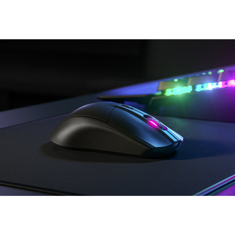 Close-up of SteelSeries Rival 3 gaming mouse showing RGB lighting effects in dark gaming setup