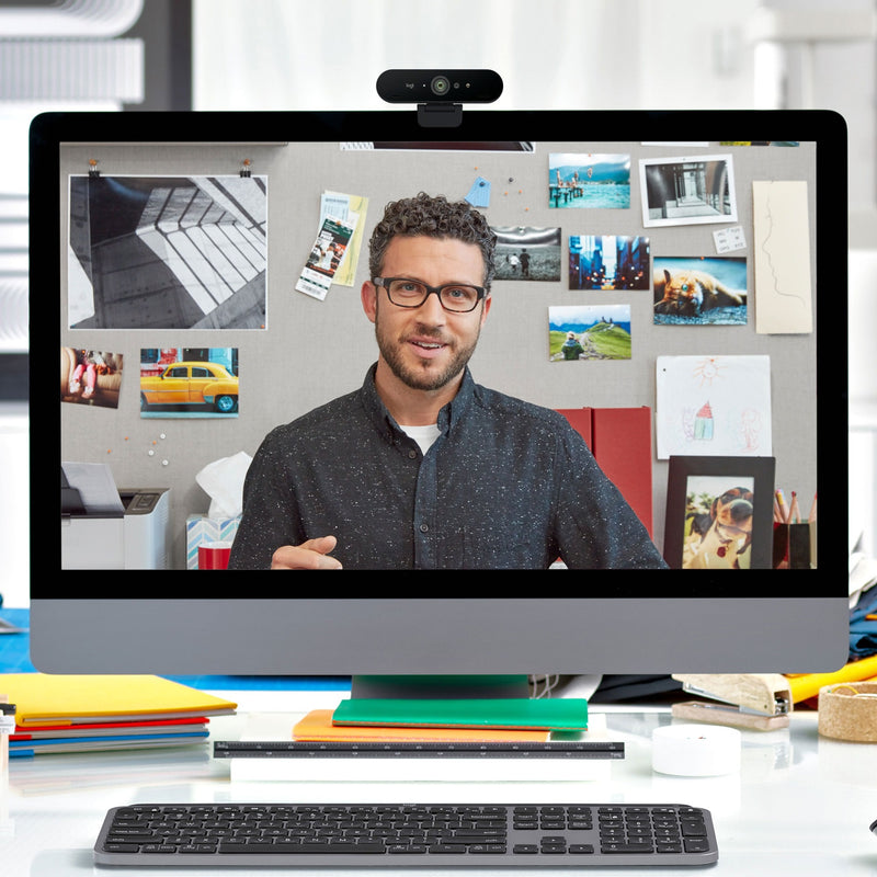 Desktop setup showing Logitech 4K PRO WEBCAM during a business presentation with analytics display