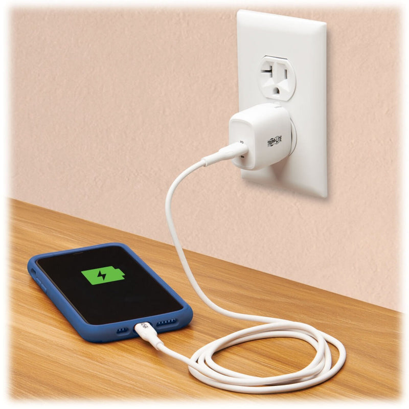 Lifestyle image showing Tripp Lite charger in use charging a smartphone on wooden surface