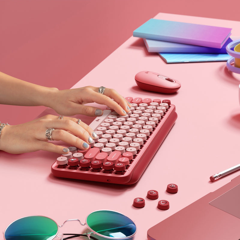 Styled desktop scene featuring POP Keys keyboard with coordinating accessories and modern office supplies