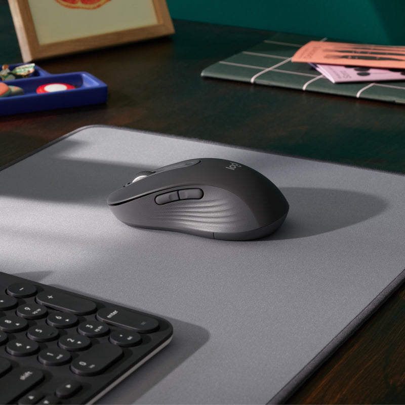 Logitech M650 L mouse on a desk with keyboard and modern office accessories