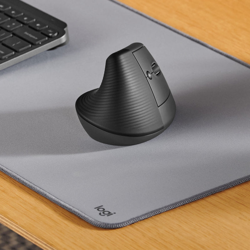 Logitech Lift mouse positioned on a gray desk mat next to a keyboard, showcasing workspace integration