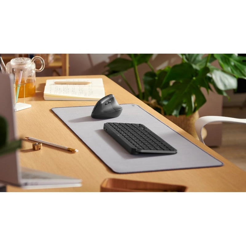 Logitech Lift Left Mouse in modern workspace setting with keyboard and accessories