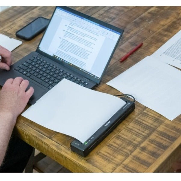 Brother PocketJet 8 printer shown in use with laptop on wooden desk-alternate-image4