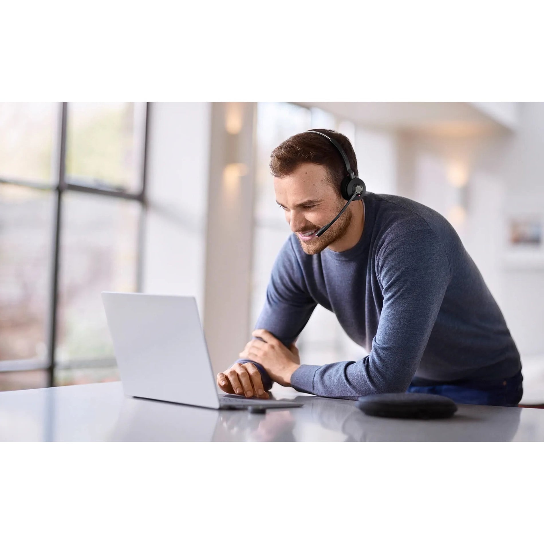 Person working on laptop while wearing Jabra Engage 55 headset in modern office environment-alternate-image10