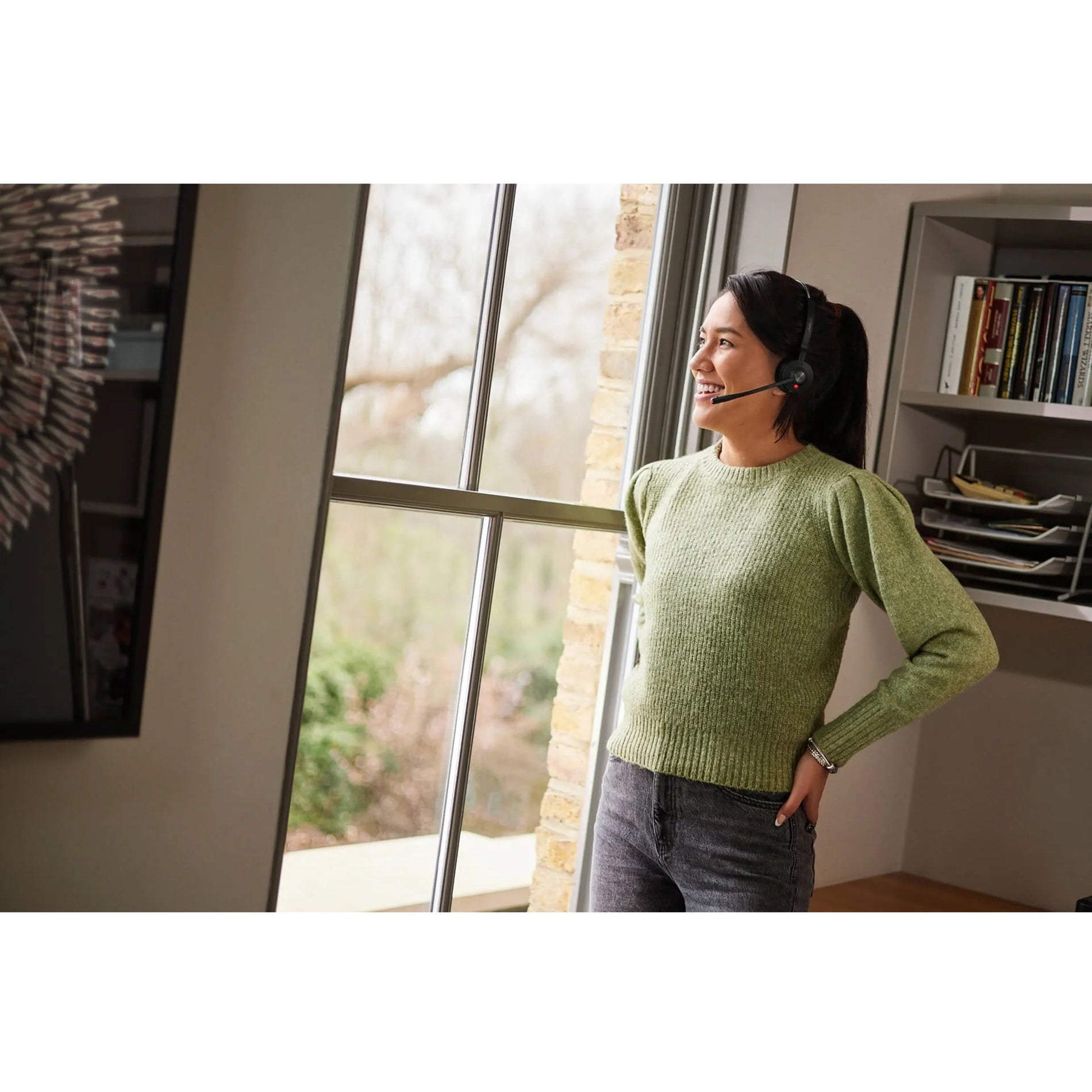 Side view of person wearing Jabra Engage 55 headset while standing near office window-alternate-image6