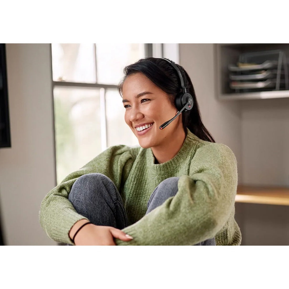 Person smiling while wearing Jabra Engage 55 headset in bright office environment-alternate-image5