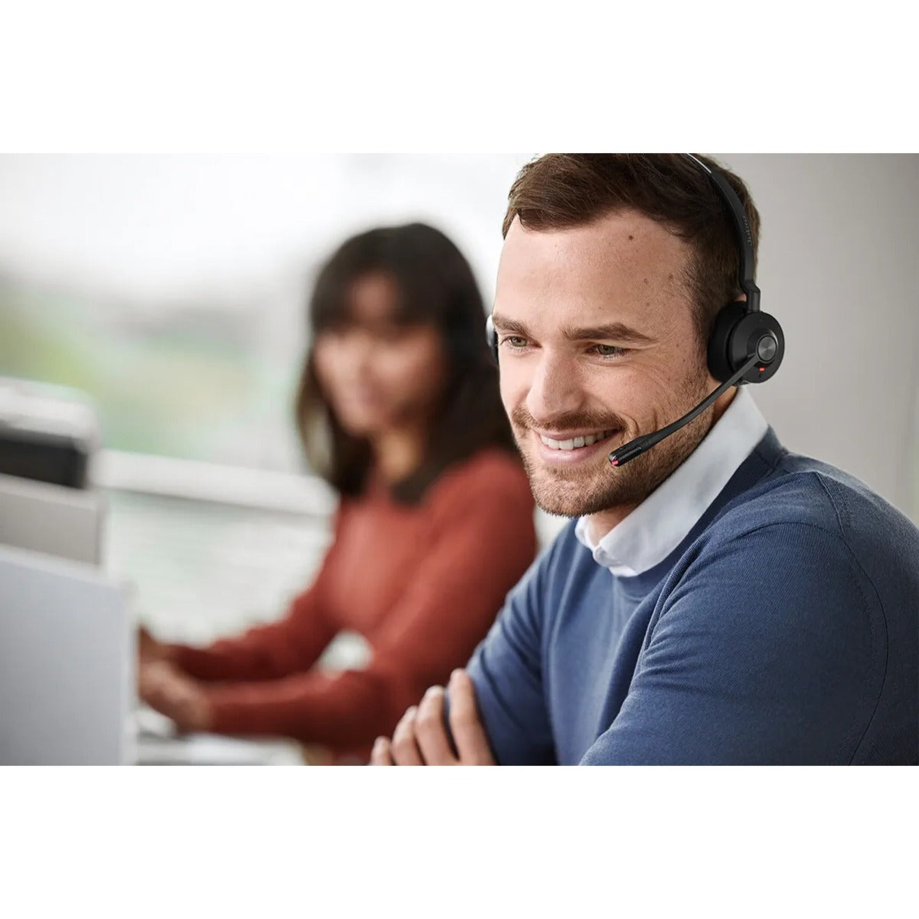 Person smiling during team meeting while wearing Jabra Engage 55 headset in office setting-alternate-image9