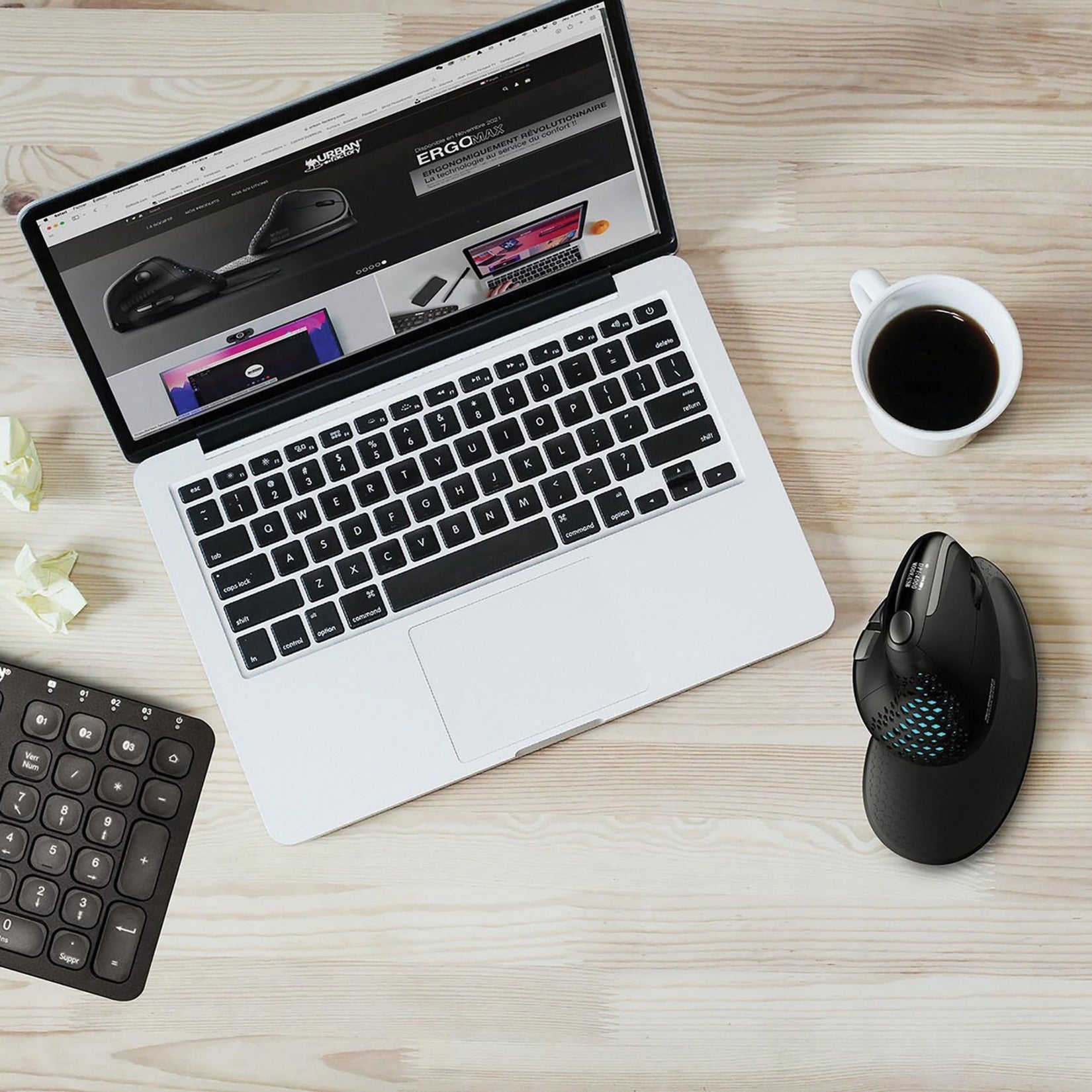 Lifestyle workspace setup showing ERGO MAX mouse alongside laptop, numeric keypad, and coffee cup on wooden desk-alternate-image4