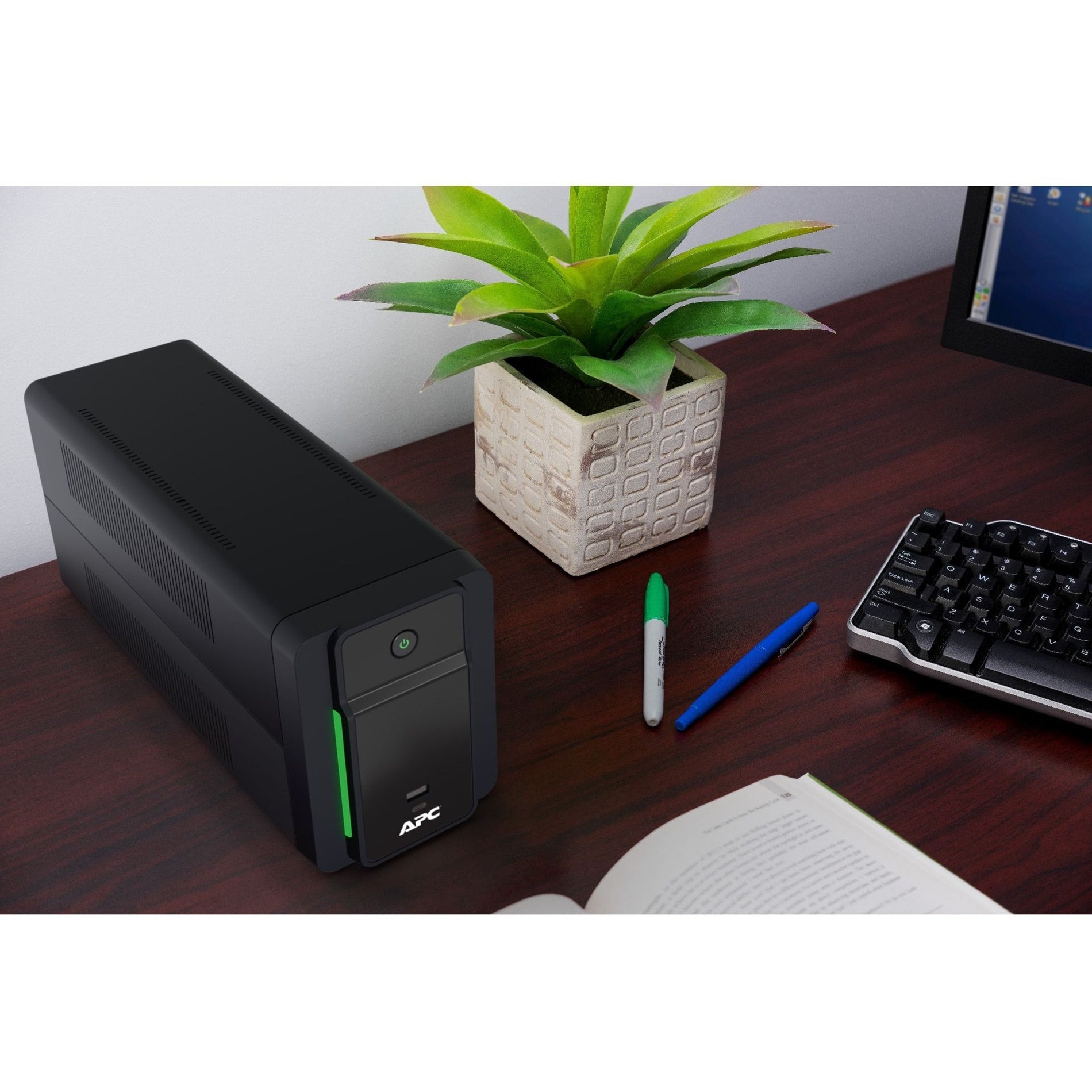 APC BVK950M2 UPS shown in a modern home office setting with desk accessories-alternate-image6