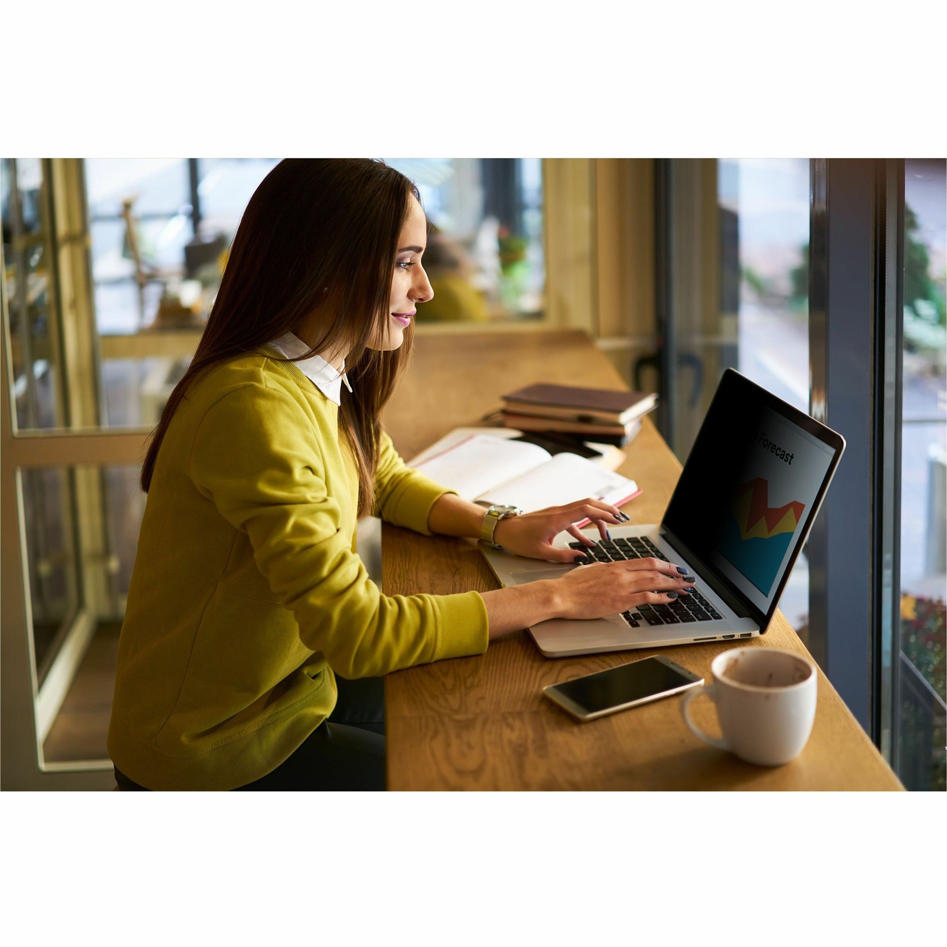 Person working on laptop with privacy screen in a bright cafe setting-alternate-image3