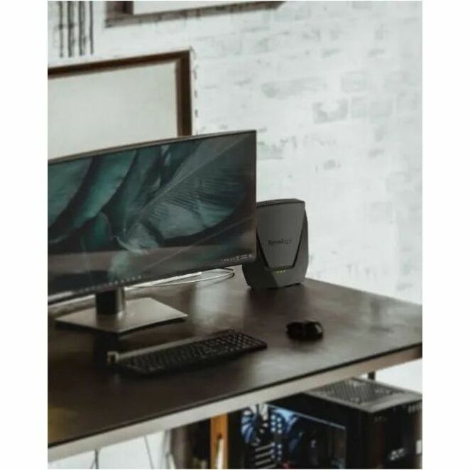 WRX560 router positioned on a desk with monitor and keyboard showing professional workspace setup