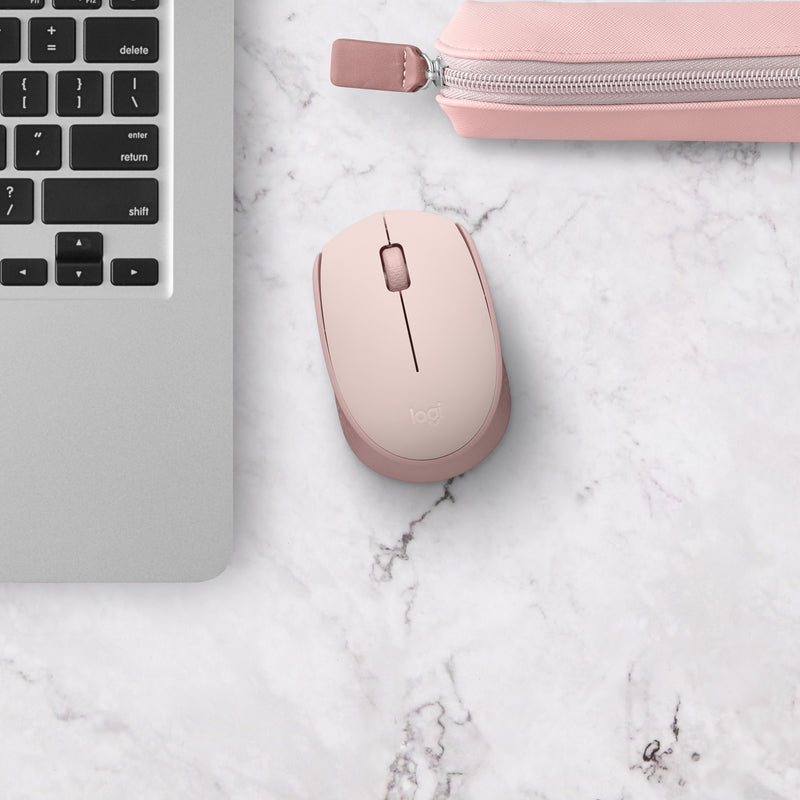 Rose gold M170 wireless mouse on marble surface next to keyboard