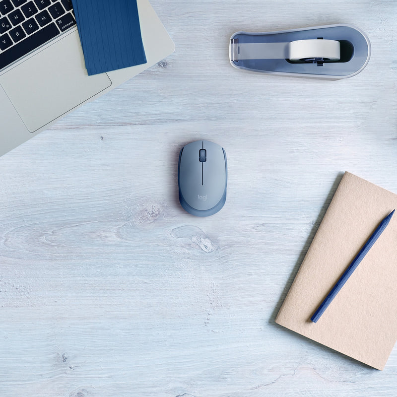 Lifestyle shot of Logitech M170 mouse with laptop and accessories showing wireless connectivity