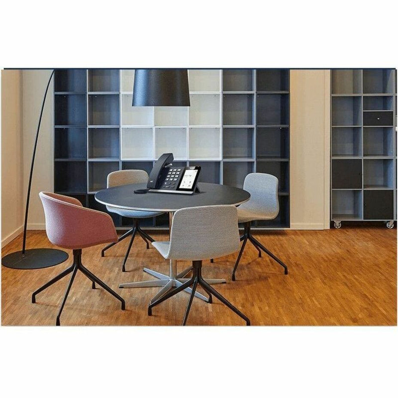 Yealink MP54-Zoom IP phone in a modern conference room setting with contemporary furniture