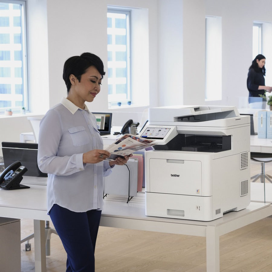 Office professional reviewing printed documents from the Brother MFC-L9610CDN printer-alternate-image4