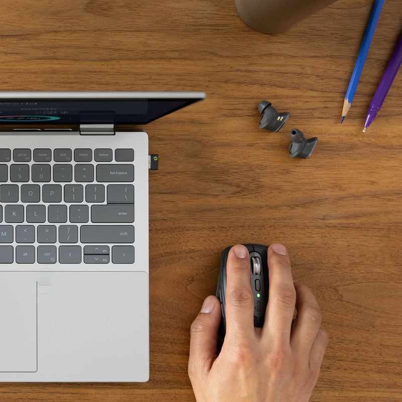 Overhead view of workspace showing MX Anywhere 3S mouse with laptop and wireless earbuds