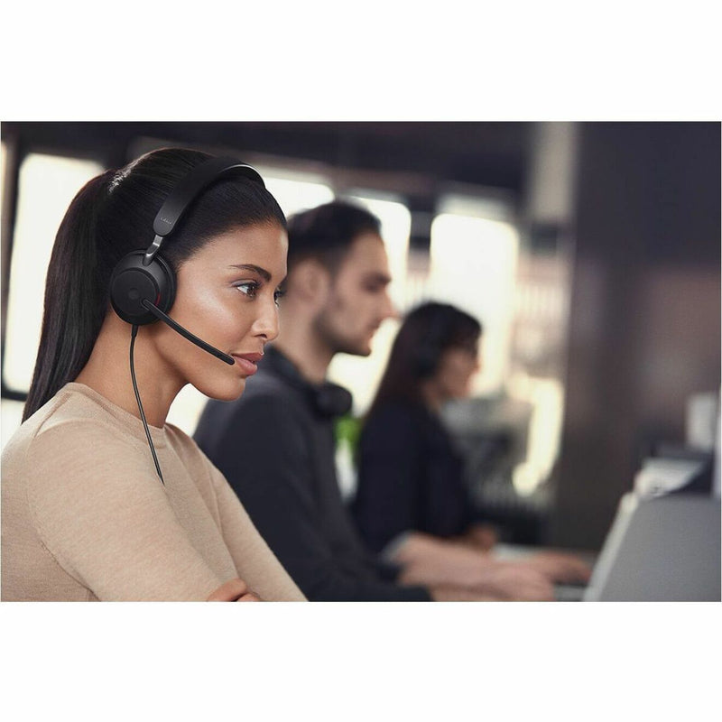 Side profile of person using Jabra Evolve2 40 SE headset in busy office