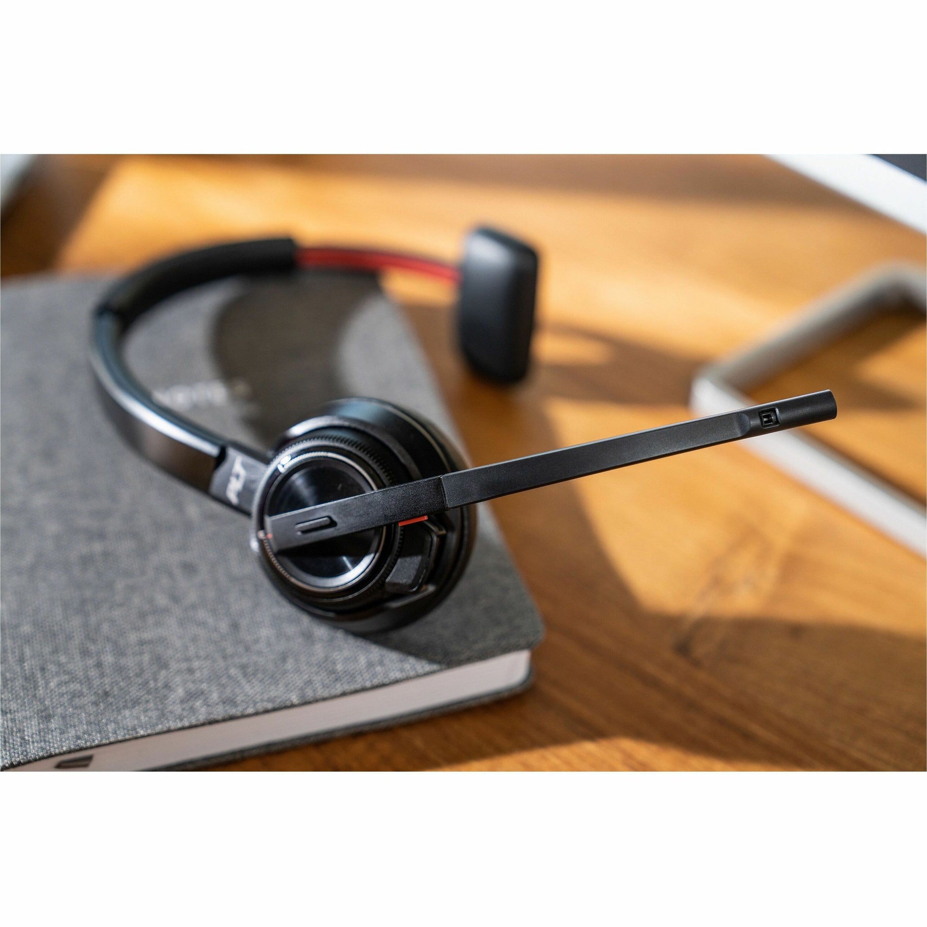 Poly Savi 8210-M headset on desk with notebook in professional setting-alternate-image5