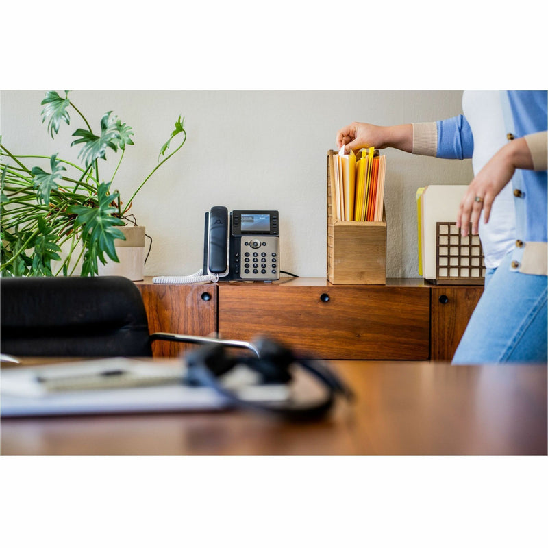 Poly Edge E320 IP phone shown in a modern office setting with desk accessories