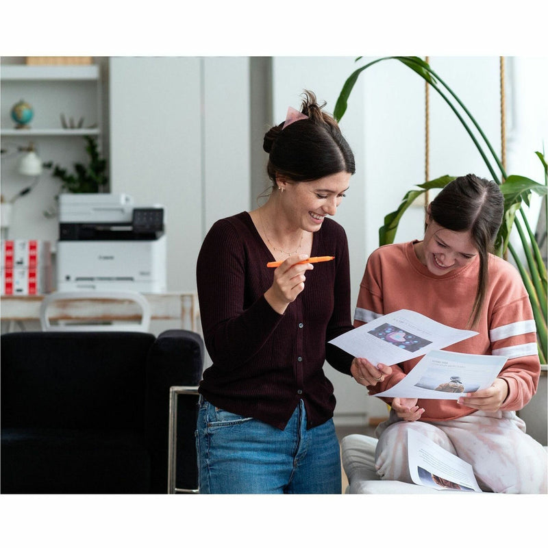 Office setting showing Canon printer with documents being reviewed by professionals