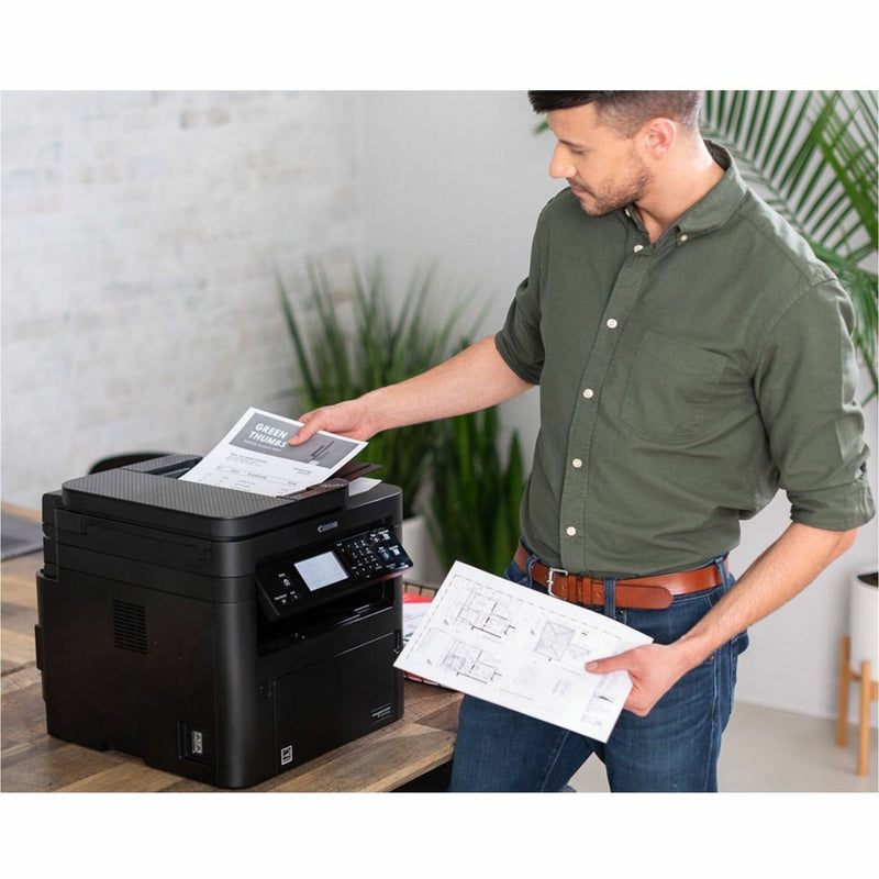 Professional using Canon printer with architectural drawings and business documents