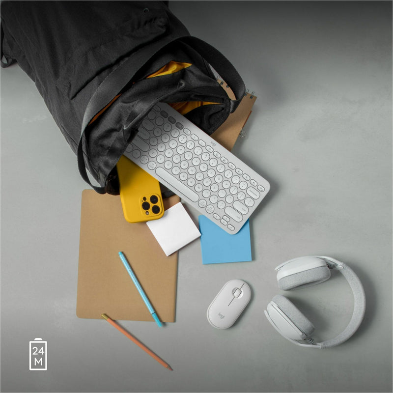 Lifestyle shot of Logitech Pebble 2 M350s with everyday carry items including keyboard and headphones