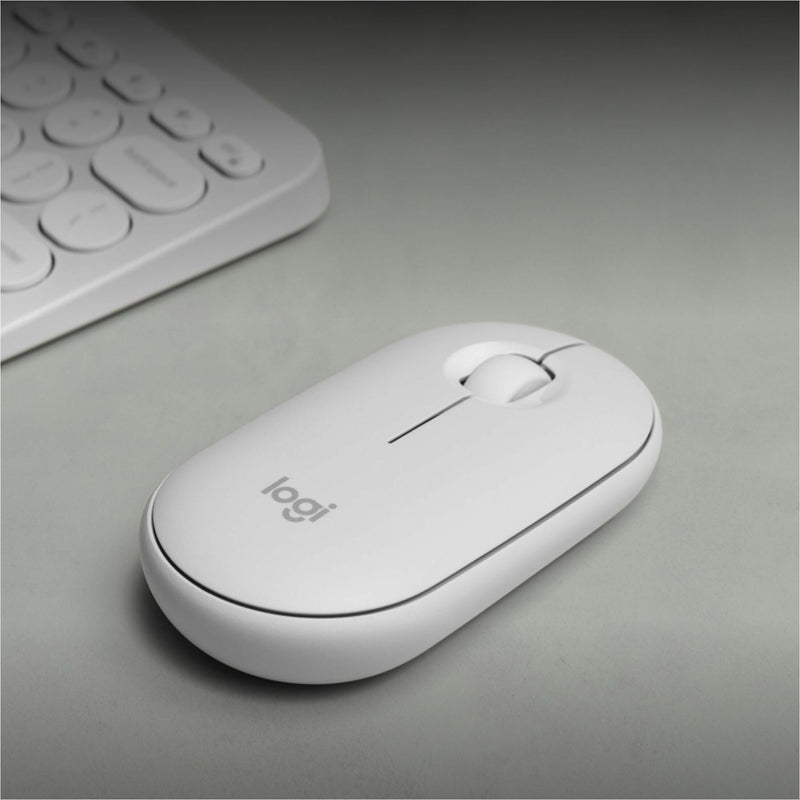 Logitech Pebble 2 M350s mouse on a desk with keyboard, showing its sleek profile and workspace integration