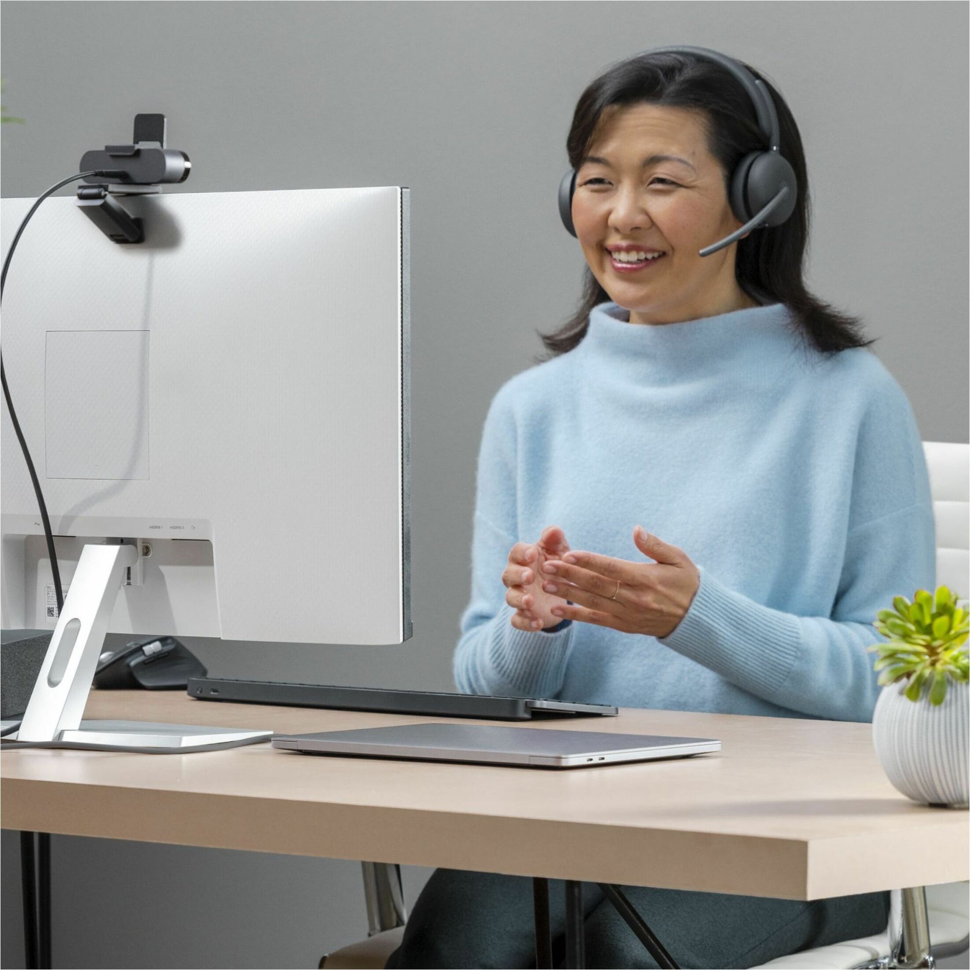 Professional using Logitech Zone 950 headset during a video conference at desk-alternate-image2