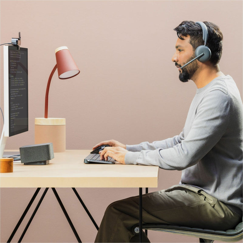 Side view of person wearing Logitech Zone 950 headset while working at computer