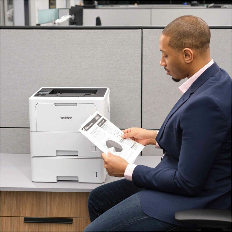 Business professional reviewing printed documents from Brother HL-L6210DWT