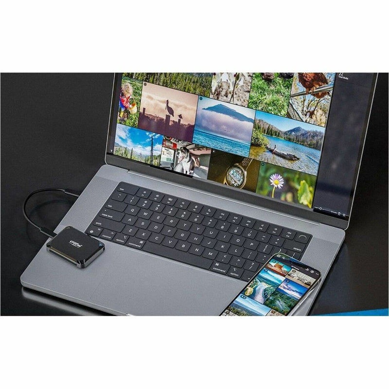 Laptop and smartphone displaying photo galleries with Crucial X9 SSD connected