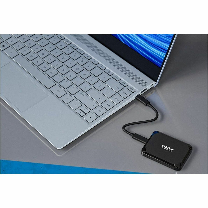 Close-up of Crucial X9 SSD connected to laptop via USB-C cable