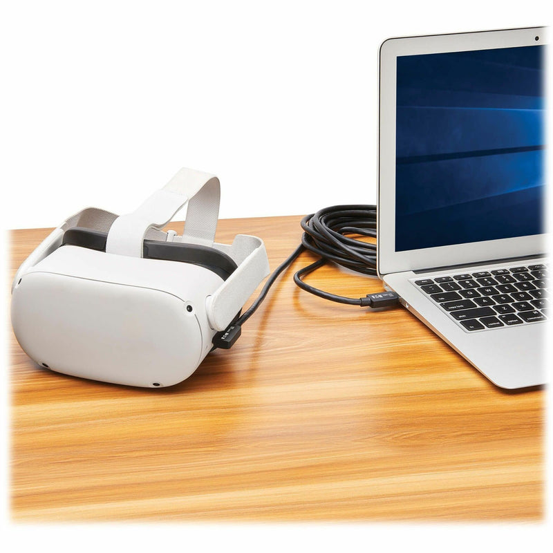 Meta Quest 2 headset connected to laptop via Tripp Lite VR Link Cable on wooden desk