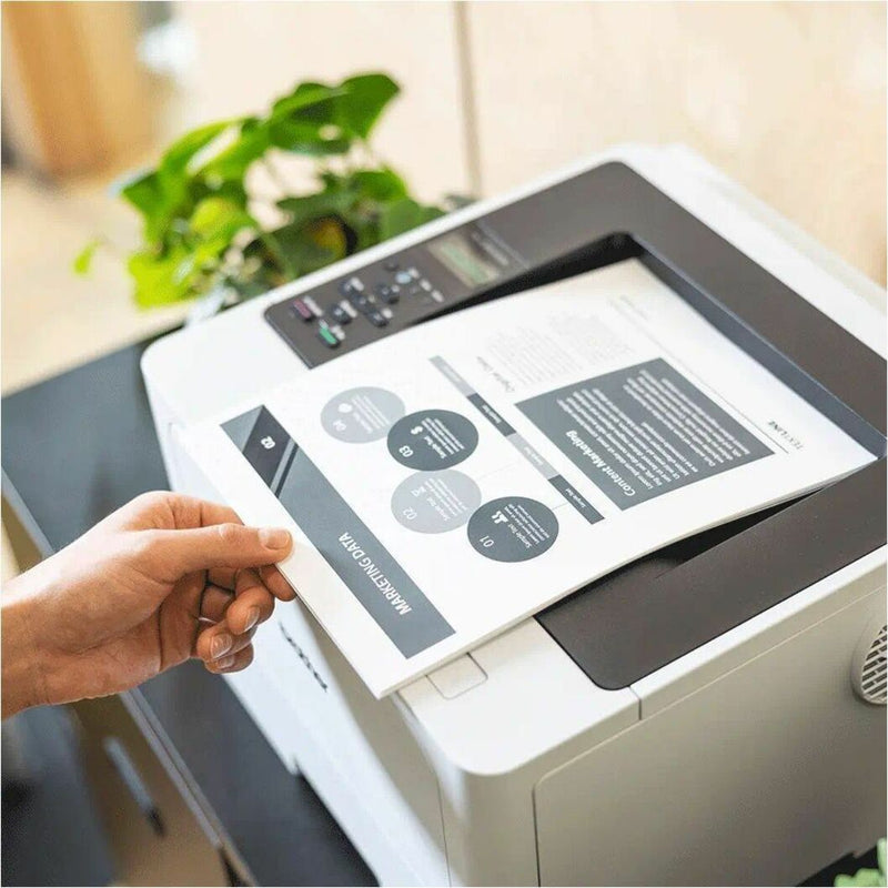 Person retrieving printed document from Brother HL-L5210DWT printer with infographic visible