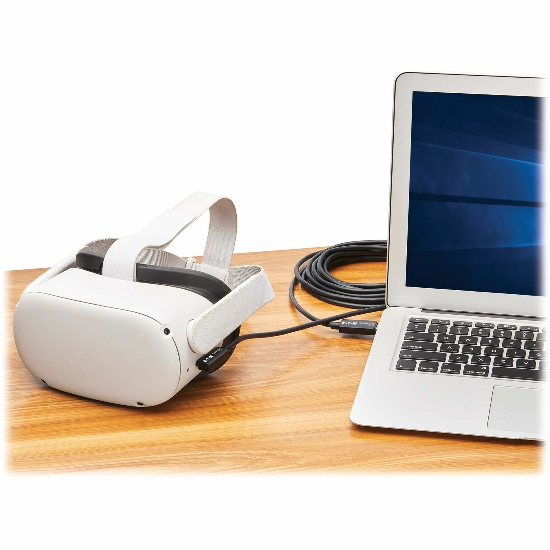 Meta Quest 2 headset connected to a laptop via Tripp Lite VR Link Cable on wooden desk-alternate-image8